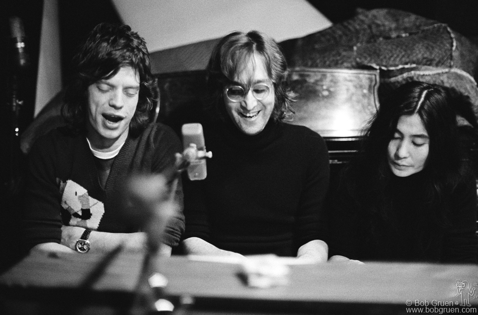(L-R) Mick Jagger of The Rolling Stones, John Lennon and Yoko Ono singing at a piano at The Record Plant, NYC. 1972. © Bob Gruen / www.bobgruen.com